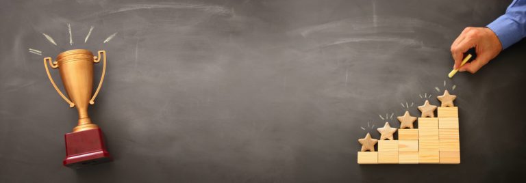 A man is holding a trophy in front of a chalkboard at an account management marketplace.