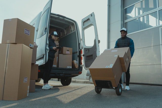 Two people loading boxes into a van for marketplace account management with My Amazon Guy.